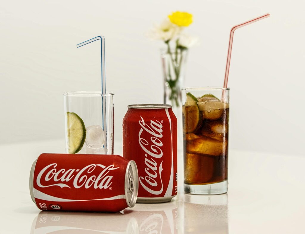 Sodas Coca-Cola cans with ice and lime on a table, fresh and invigorating.