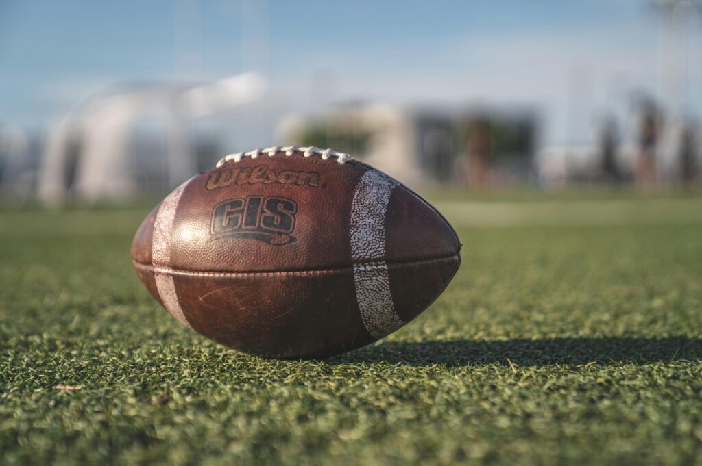 American Football Close-up of a Wilson football on green grass in an outdoor sports setting, perfect for sports-themed visuals.