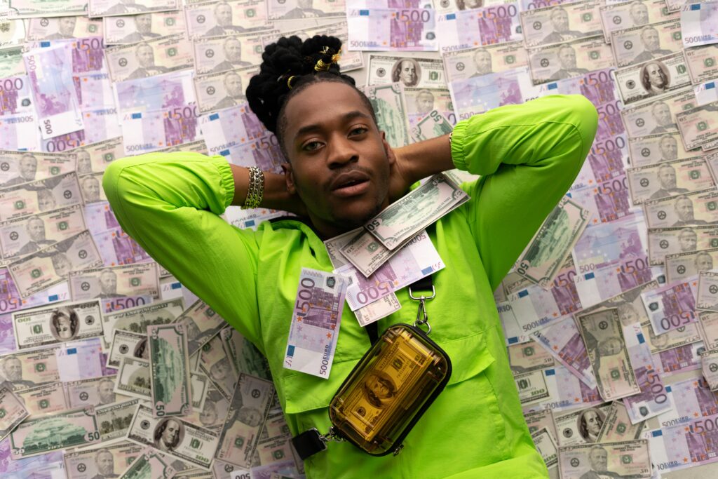 Rap Music African American man in green outfit lying on a bed of dollar and euro banknotes, symbolizing wealth.